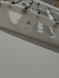 Close-up photo of a single rib joint, showing the hardware and rod connections that let the skin rotate.